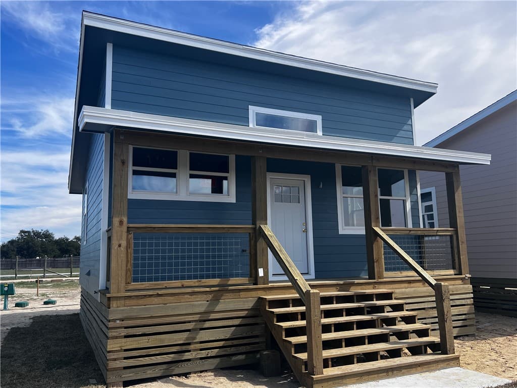 Cottage on wood piers with a covered porch and railing